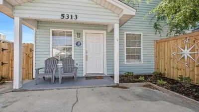 two chairs sitting on the front porch of a house at Blue & Red Neptune by Nautical Properties Vacation Rentals in Panama City Beach