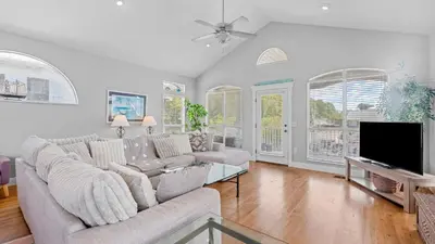 a living room with a couch and a flat screen tv at Walk to Santa Rosa Beach Private Pool Balcony and Coastal Views in Santa Rosa Beach