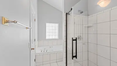 a white bathroom with a shower and a tub at Walk to Santa Rosa Beach Private Pool Balcony and Coastal Views in Santa Rosa Beach