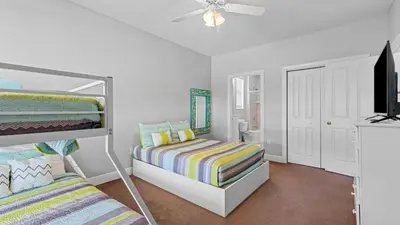 a bedroom with two bunk beds and a flat screen tv at Walk to Santa Rosa Beach Private Pool Balcony and Coastal Views in Santa Rosa Beach