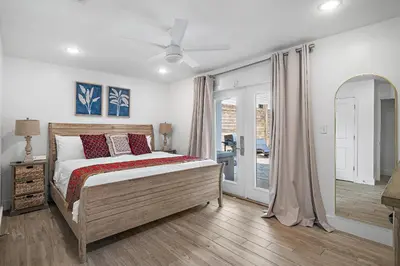a bedroom with a bed and a mirror at Beach & Bubbles in Santa Rosa Beach