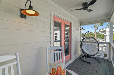 a porch with a rocking chair and a ceiling fan at Beach & Bubbles in Santa Rosa Beach