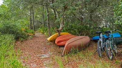 a group of kayaks and a bike on a trail at Heron's Watch 6207 in Santa Rosa Beach
