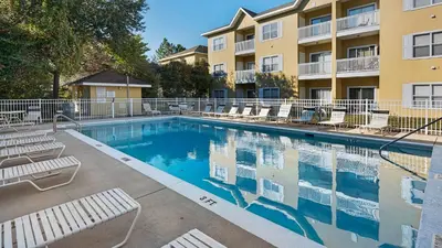 a swimming pool with lounge chairs in front of a building at Heron's Watch 6207 in Santa Rosa Beach