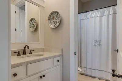 a bathroom with a sink and a toilet and a mirror at Gram's Beach Spot in Santa Rosa Beach