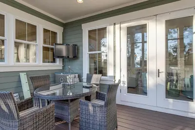 a screened porch with a glass table and chairs at Gram's Beach Spot in Santa Rosa Beach