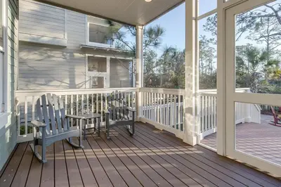 a porch with two chairs and a table at Gram's Beach Spot in Santa Rosa Beach