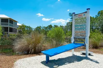 a blue bench in front of a sign at Gram's Beach Spot in Santa Rosa Beach