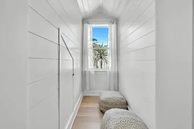 a white hallway with two chairs and a window at Saltaire-2 in Santa Rosa Beach