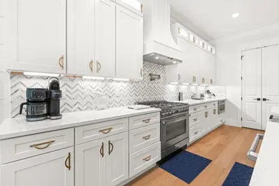 a white kitchen with white cabinets and a stove at Casa Al Mare in Santa Rosa Beach