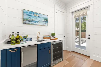 a kitchen with white walls and blue cabinets at Casa Al Mare in Santa Rosa Beach