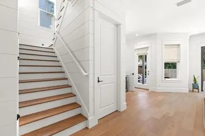 a white staircase in a home with white walls and wooden floors at Casa Al Mare in Santa Rosa Beach