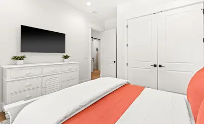 a white bedroom with a bed and a tv at Casa Al Mare in Santa Rosa Beach