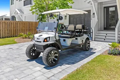 a white golf cart parked in a yard at Casa Al Mare in Santa Rosa Beach
