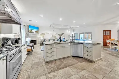 a large kitchen with white cabinets and stainless steel appliances at Saltaire in Santa Rosa Beach