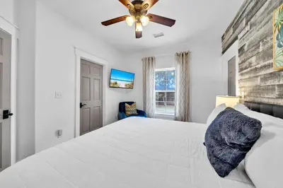 a bedroom with a white bed and a ceiling fan at Saltaire in Santa Rosa Beach