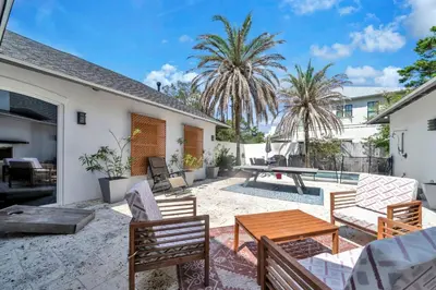 a patio with a wooden table and chairs at Saltaire in Santa Rosa Beach
