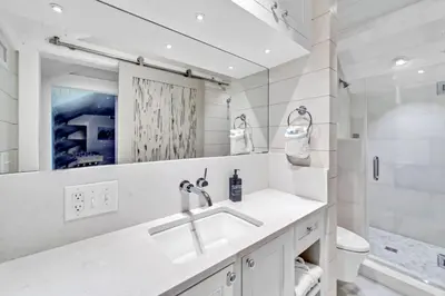 a bathroom with a sink and a toilet and a mirror at Saltaire in Santa Rosa Beach