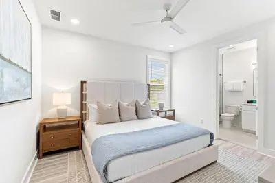 a white bedroom with a bed and a bathroom at Above It All in Inlet Beach