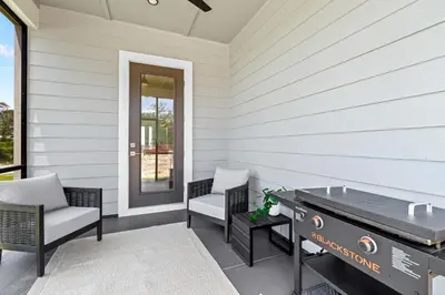 a patio with a ping pong table and chairs at Above It All in Inlet Beach
