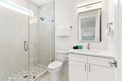 a white bathroom with a toilet and a shower at Above It All in Inlet Beach