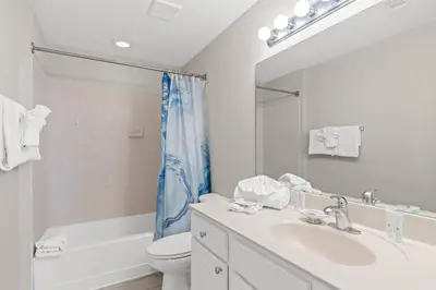 a bathroom with a sink and a toilet and a mirror at Tidewater 2615 in Panama City Beach