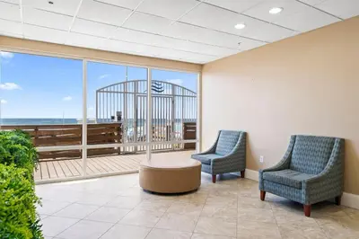 two chairs and a table in a room with a large window at Tidewater 2615 in Panama City Beach