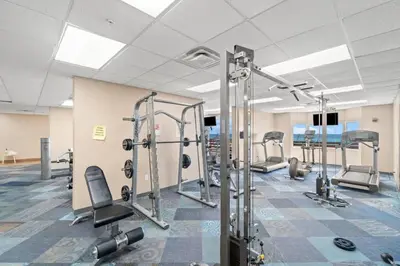 a gym with several tread machines in a room at Tidewater 2615 in Panama City Beach