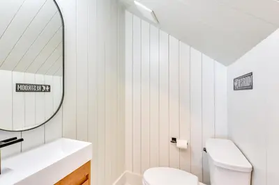 a bathroom with a white toilet and a mirror at Walk to Laguna Beach PCB Home with Pool Near Gulf! in Panama City Beach