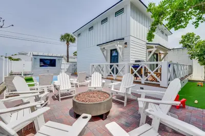 a patio with white chairs and a fire pit at Walk to Laguna Beach PCB Home with Pool Near Gulf! in Panama City Beach
