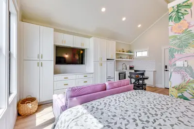 a bedroom with a purple bed and a kitchen at Walk to Laguna Beach Modern Studio in PCB! in Panama City Beach