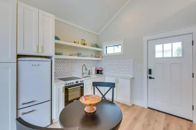 a kitchen with a table and a refrigerator at Walk to Laguna Beach Modern Studio in PCB! in Panama City Beach
