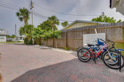 two bikes parked in a driveway next to a fence at Walk to Laguna Beach Modern Studio in PCB! in Panama City Beach