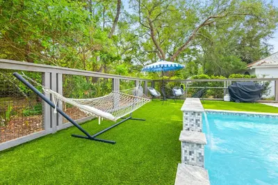 a swimming pool with a hammock and an umbrella at 30A Seacrest Beach Access PoolGolf CartBikes in Inlet Beach