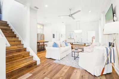 a living room with white furniture and a staircase at 30A Seacrest Beach Access PoolGolf CartBikes in Inlet Beach