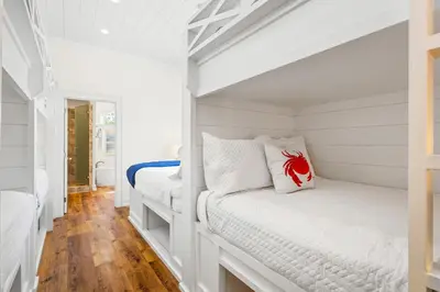 a white room with two bunk beds in it at 30A Seacrest Beach Access PoolGolf CartBikes in Inlet Beach