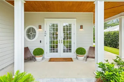 a front door of a house with two chairs at 30A Seacrest Beach Access PoolGolf CartBikes in Inlet Beach