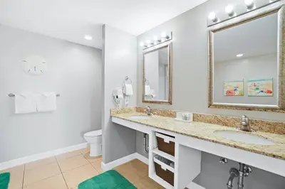 a bathroom with two sinks and a toilet at Oceanfront Penthouse CornerUnit 1950sf with beach service in Panama City Beach