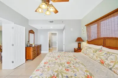 a bedroom with a large bed and a ceiling fan at Oceanfront Penthouse CornerUnit 1950sf with beach service in Panama City Beach