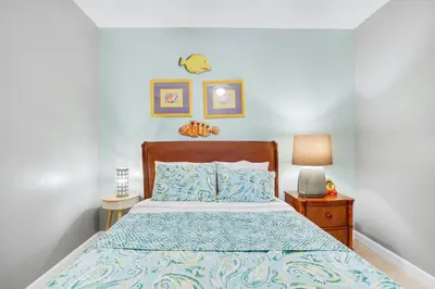 a bedroom with a bed with a blue comforter at Oceanfront Penthouse CornerUnit 1950sf with beach service in Panama City Beach