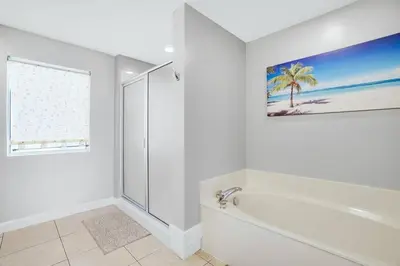 a white bathroom with a bath tub and a window at Oceanfront Penthouse CornerUnit 1950sf with beach service in Panama City Beach
