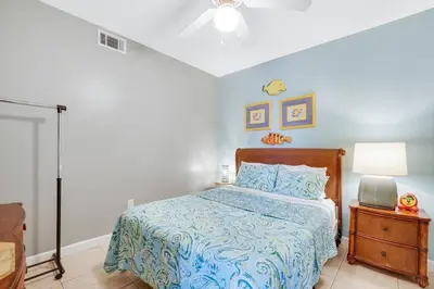 a bedroom with a bed with a blue comforter at Oceanfront Penthouse CornerUnit 1950sf with beach service in Panama City Beach