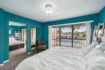 a bedroom with a large bed and a balcony at Beachwalk 17B home in Panama City Beach
