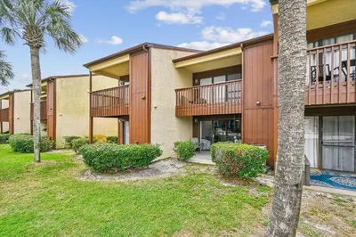 an exterior view of a building with palm trees at Beachwalk 17B home in Panama City Beach