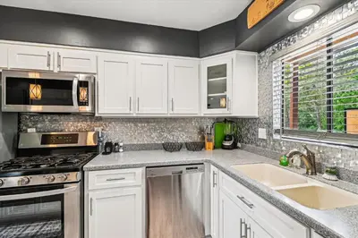 a kitchen with white cabinets and stainless steel appliances at Beachwalk 17B home in Panama City Beach