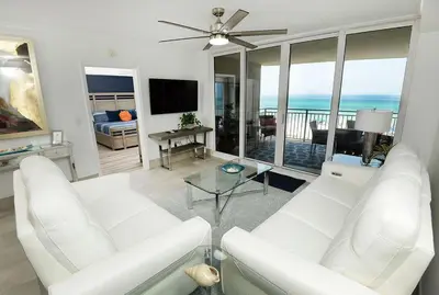 a living room with white furniture and a view of the ocean at Emerald Beach 325 in Panama City Beach