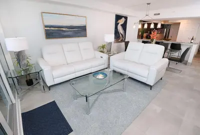 a living room with two white couches and a table at Emerald Beach 325 in Panama City Beach