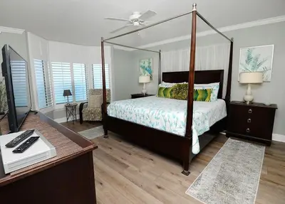 a bedroom with a canopy bed and a desk at Emerald Beach 1130 in Panama City Beach