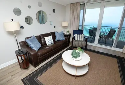 a living room with a couch and a table at Emerald Beach 1130 in Panama City Beach