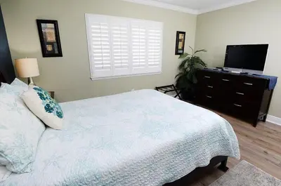 a bedroom with a bed and a flat screen tv at Emerald Beach 1130 in Panama City Beach